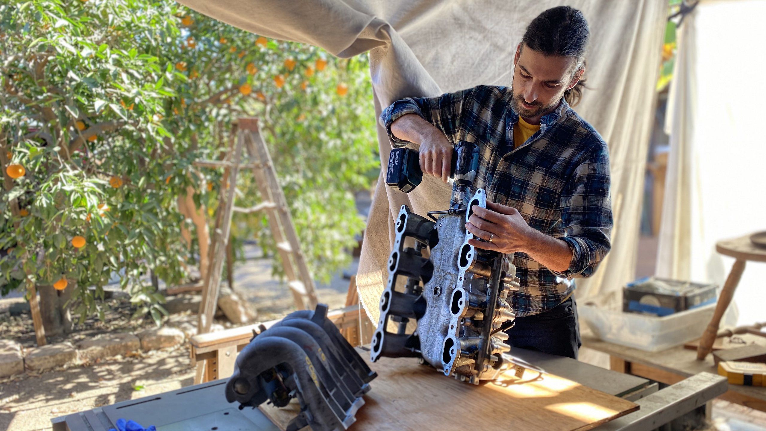 Designer Tada Ryvola-Marez of LA-based United Environment Architecture works on discarded inlet manifolds to construct a time capsule to be stored at the Red Cross Red Crescent Museum in Geneva. (UEA)