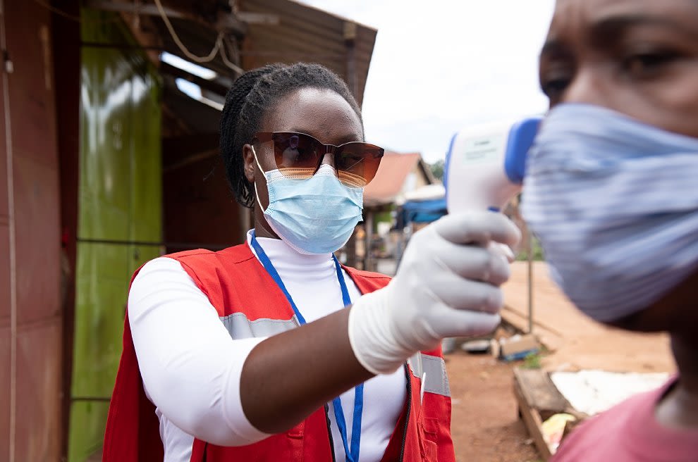 A Uganda Red Cross volunteer takes a spot temperature in a Covid check. (Uganda Red Cross Society)